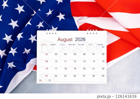 August 2026 desk calendar and United States of America flag on table, Flat lay. 126141639