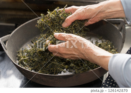 炮烙鍋でお茶の葉を乾燥しているシニア女性 126142870