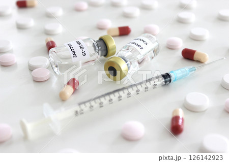 Vial of Covid-19 vaccine, 1 ml plastic syringe with needle and drugs isolated on the white background 126142923