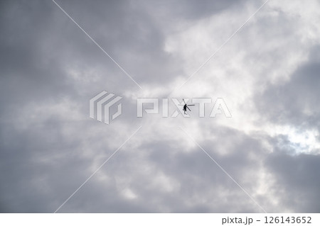 One helicopter, no others. Sky above hangs thick and quiet. Lines remain simple. Darkness within motion suggests distance, intention, or watchfulness beneath the grey. 126143652