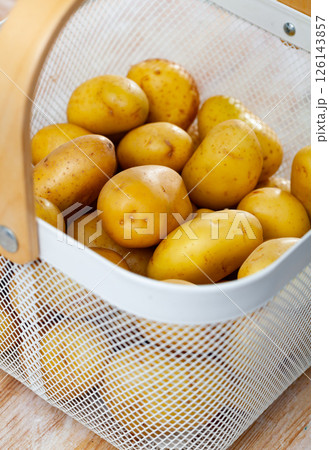 Pile of clean young potato tubers in basket Pile of clean young potato tubers in basket 126143857