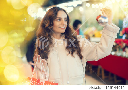 Woman choosing Christmas balls 126144012