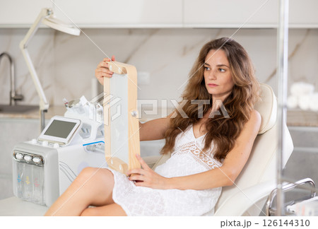 examining her reflection with satisfaction examining her reflection with satisfaction 126144310