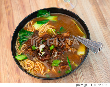Beef soup with noodles and vegetables on a wooden background Beef soup with noodles and vegetables on a wooden background 126144686