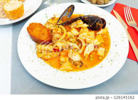 Tasty dish of spanish cuisine fried sepia with mussels in sauce Tasty dish of spanish cuisine fried sepia with mussels in sauce 126145162