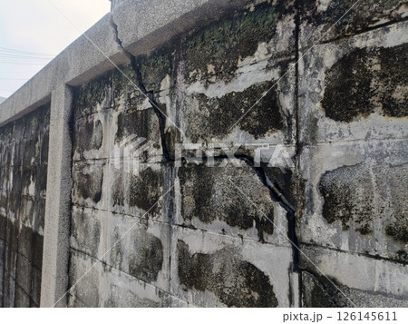 A crack wall concrete damage block texture surface pattern weathered old building broken structure cement aged exterior background architecture construction fracture flaw imperfection defect failure 126145611