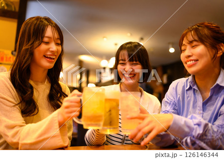 居酒屋で乾杯をする20代の女性 126146344
