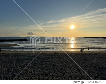 海に沈む夕日と砂浜で遊ぶ人々｜夏の思い出 126146715
