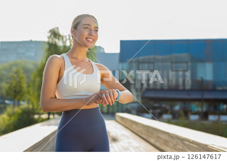 Young female runner looks at smartwatch device fitness bracelet heart rate, pulse, SPO2 in city park Young female runner looks at smartwatch device fitness bracelet heart rate, pulse, SPO2 in city park 126147617