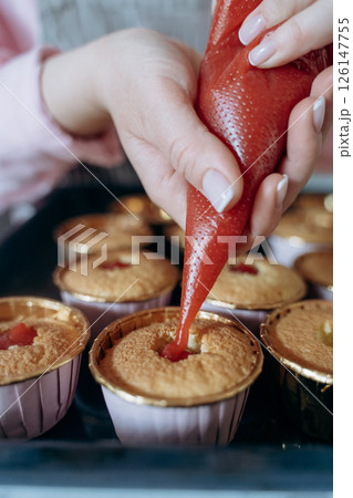 Filling Cupcakes with Strawberry Sauce from Piping Bag 126147755