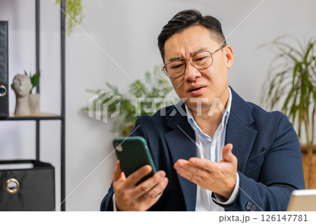 Asian office business man use smartphone surprised by bad news, fortune loss, fail, lottery results Asian office business man use smartphone surprised by bad news, fortune loss, fail, lottery results 126147781