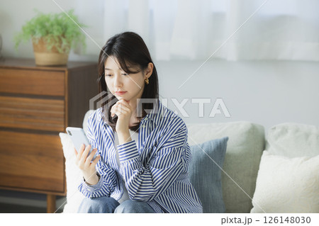 スマホを見て困った顔の若い女性 スマホを見て困った顔の若い女性 126148030
