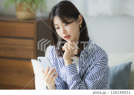 スマホを見て困った顔の若い女性 スマホを見て困った顔の若い女性 126148031