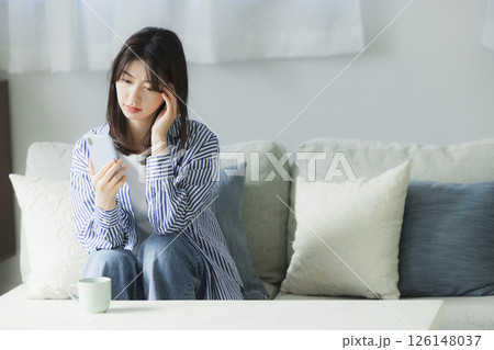 スマホを見て困った顔の若い女性 スマホを見て困った顔の若い女性 126148037