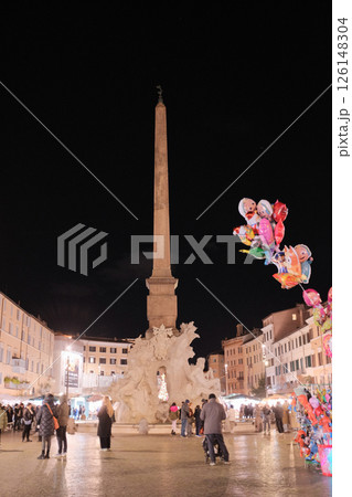 Night scene at Piazza Navona Rome with colorful balloons illuminated street lights and people in festive lively evening atmosphere Italy. High quality photo 126148304