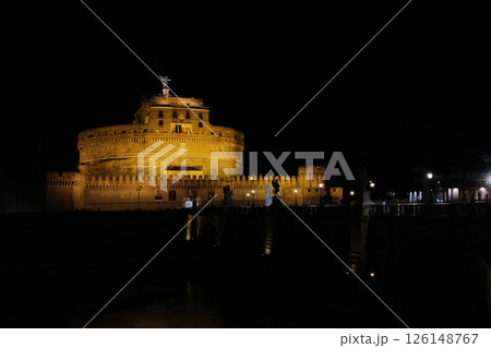Illuminated Castel Sant Angelo and Ponte Sant Angelo over Tiber River at night in Rome with reflections on water historical architecture and iconic view 126148767