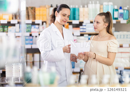 Pregnant woman chooses prescription pills with help of pharmacist Pregnant woman chooses prescription pills with help of pharmacist 126149321