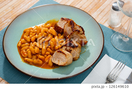 Delicious meat dish of roast pork and stewed beans on blue plate Delicious meat dish of roast pork and stewed beans on blue plate 126149610
