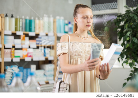 pregnant woman chooses a cream at the pharmacy 126149683