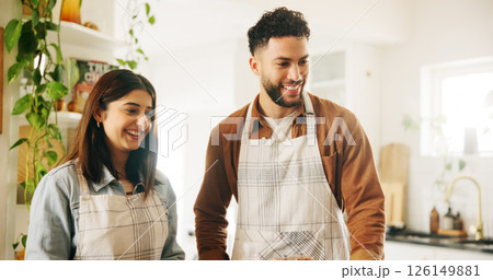 Couple, happy and cooking in kitchen, home and partnership with support, nutrition or food for meal prep. People, man and woman with smile, apron and excited with help, diet and bonding at apartment Couple, happy and cooking in kitchen, home and partnership with support, nutrition or food for meal prep. People, man and woman with smile, apron and excited with help, diet and bonding at apartment 126149881