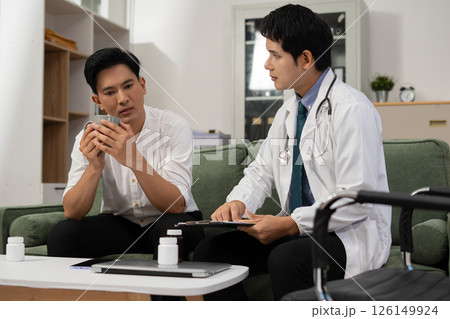Concerned male patient, patient talks with healthcare professional and signing medical paper at appointment visit in clinic. Concerned male patient, patient talks with healthcare professional and signing medical paper at appointment visit in clinic. 126149924