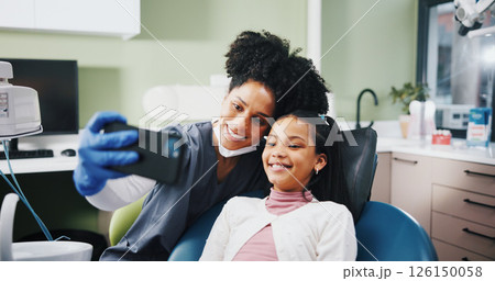 Dentist, woman and child with selfie, happy and excited for results, cleaning or tooth extraction at clinic. People, girl and smile with teeth whitening, care and photography with doctor at hospital 126150058