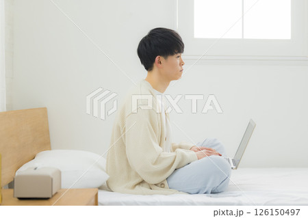 ベッドでノートパソコンを操作する男性 ベッドでノートパソコンを操作する男性 126150497