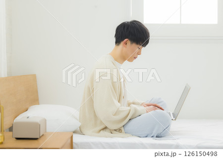 ベッドでノートパソコンを操作する男性 ベッドでノートパソコンを操作する男性 126150498