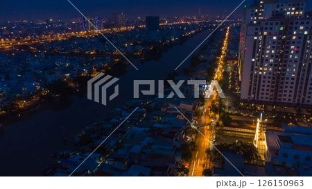 Aerial view of illuminated church by river surrounded by high rise residential buildings and city streets during blue hour with urban skyline and canal cityscape at twilight. High quality photo Aerial view of illuminated church by river surrounded by high rise residential buildings and city streets during blue hour with urban skyline and canal cityscape at twilight. High quality photo 126150963