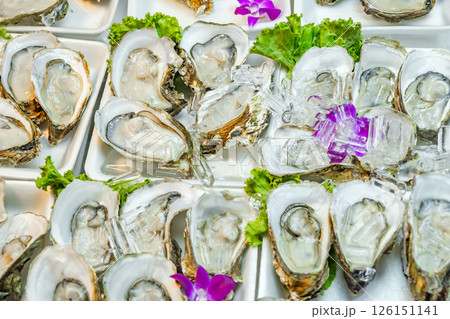 fresh raw oysters with ice decorated with flowers at grocery street market 126151141