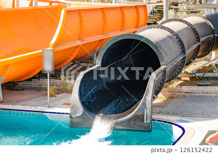 water flows down black water slide in water park water flows down black water slide in water park 126152422