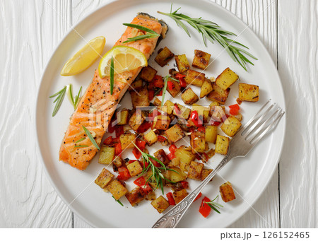 Oven-baked salmon fillet with fried potato, lemon 126152465