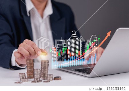 Businessman stacking coins with digital financial graph, representing investment growth, financial success, and real estate market trends. Ideal for finance and business concepts. Businessman stacking coins with digital financial graph, representing investment growth, financial success, and real estate market trends. Ideal for finance and business concepts. 126153162