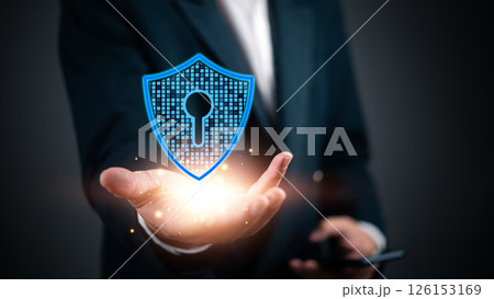 Cybersecurity concept with a business professional holding a virtual security shield. Ideal for illustrating data protection, encryption, and online safety in digital business environments. Cybersecurity concept with a business professional holding a virtual security shield. Ideal for illustrating data protection, encryption, and online safety in digital business environments. 126153169