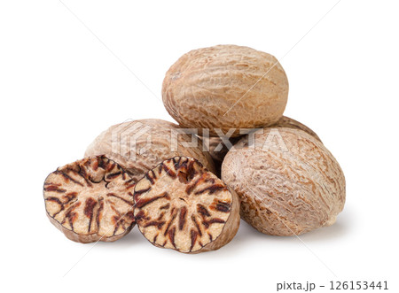 Heap of nutmeg and pieces on a white background. Isolated 126153441