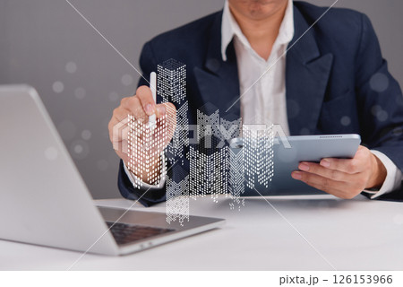person analyzing urban development and real estate market growth through a tablet with futuristic building models and digital analysis. 126153966