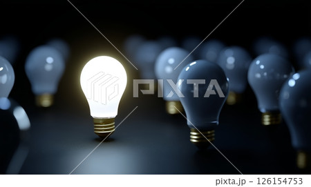 Unique light bulb shines brightest among many others in a dark setting to symbolize innovation and ideas 126154753