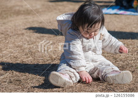 【相模原市立麻溝公園の芝生広場で遊ぶ1歳児　座る】 126155086