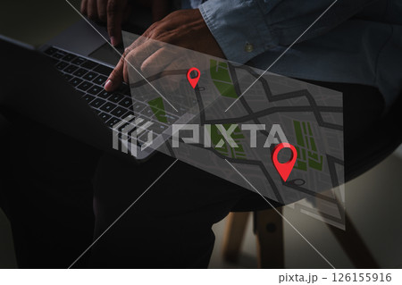 GPS tracking system real-time person using laptop with digital map overlay showing location markers, indicating navigation or route planning 126155916
