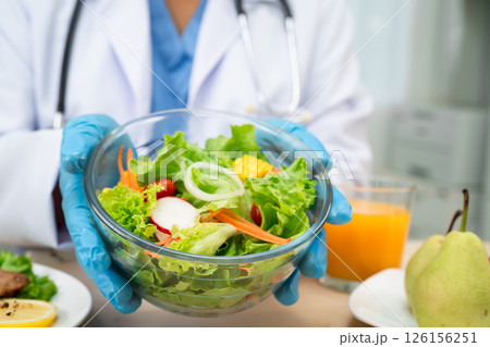Nutritionist doctor holding various healthy fresh vegetables for patient. Nutritionist doctor holding various healthy fresh vegetables for patient. 126156251