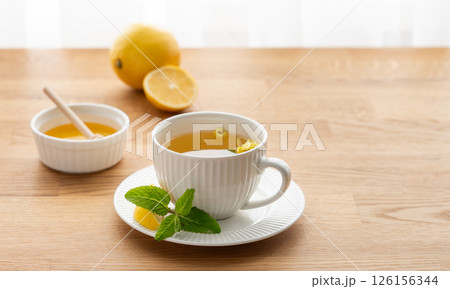 Cup of herbal tea with lemon, honey and mint on wooden tabletop Cup of herbal tea with lemon, honey and mint on wooden tabletop 126156344