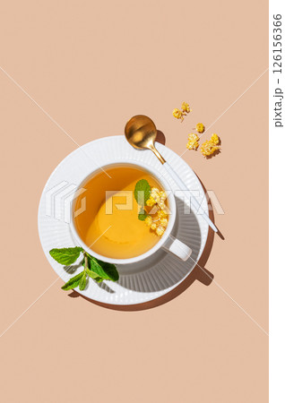Cup of herbal tea with lemon and mint on beige background with morning shadows. Cup of herbal tea with lemon and mint on beige background with morning shadows. 126156366