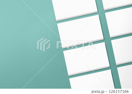 Top view of a row of business cards on a cyan background. Blank paper or sheet. Mockup or copy space for your design Top view of a row of business cards on a cyan background. Blank paper or sheet. Mockup or copy space for your design 126157166