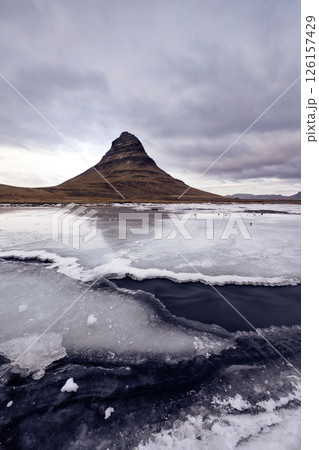 Flowing water from Kirkjufellsfoss waterfall with a view of Kirkjufell mountain on peninsula, Iceland Flowing water from Kirkjufellsfoss waterfall with a view of Kirkjufell mountain on peninsula, Iceland 126157429