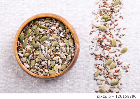 5-Seed snack mix, raw seeds and kernels in a wooden bowl on linen. Sunflower and pumpkin kernels, flax and chia seeds, and whole hemp seeds. A crunchy snack, for smoothies, as a topping or for baking. 5-Seed snack mix, raw seeds and kernels in a wooden bowl on linen. Sunflower and pumpkin kernels, flax and chia seeds, and whole hemp seeds. A crunchy snack, for smoothies, as a topping or for baking. 126158290