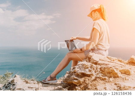 Woman Working on Laptop with Ocean View Woman Working on Laptop with Ocean View 126158436