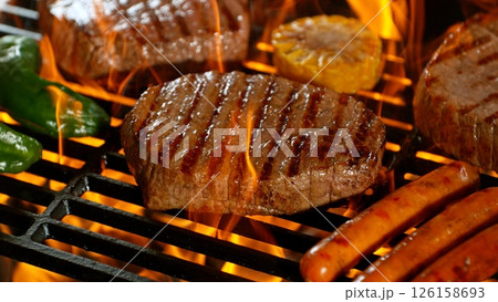 Close-up of Beef Steak on Barbeque Grill with Roaring Flames 126158693