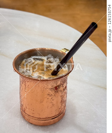 Chilled iced coffee with straw in a metal cup. 126158754