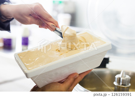 Creamy ice cream in tray against the background of equipment for making ice cream 126159391