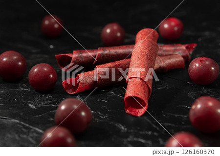 Fruit peel of cherry in rolls. Pastila. Background for text and articles about eating healthy. Raw food diet, vegan sweetness, dessert without sugar and flour. Cherry background. 126160370